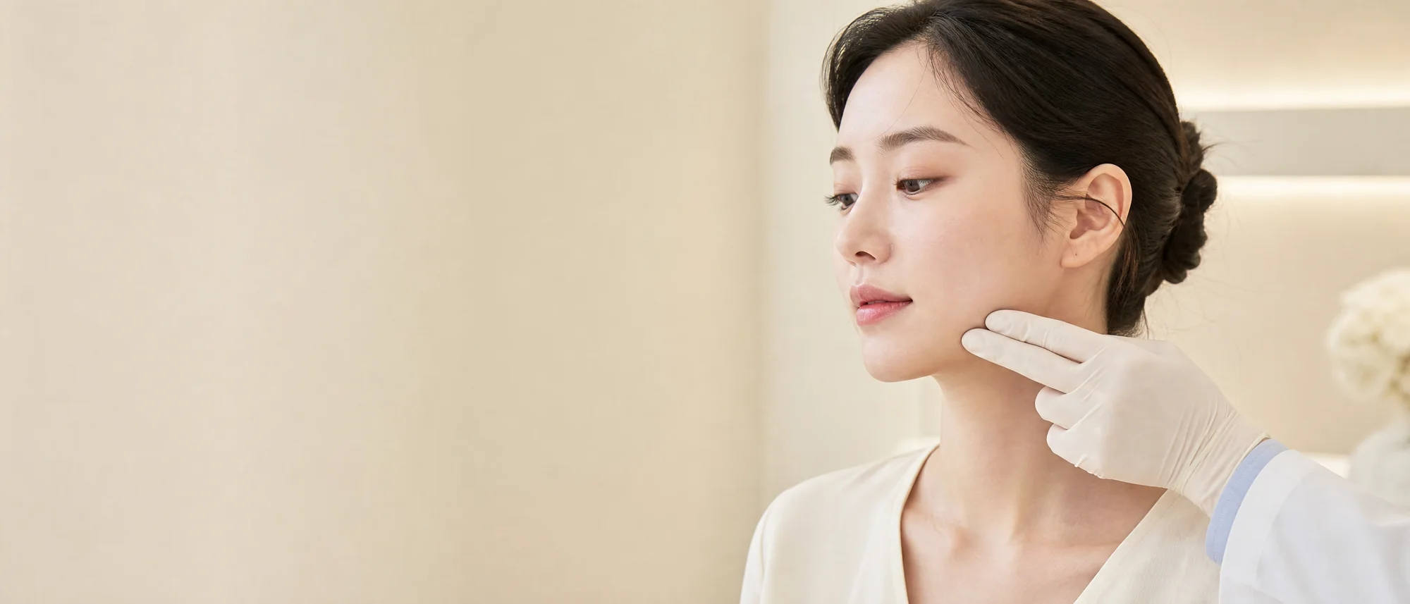 의료진이 장갑 낀 손으로 20대 여성의 턱선을 짚으며 실리프팅 라인을 디자인하는 장면