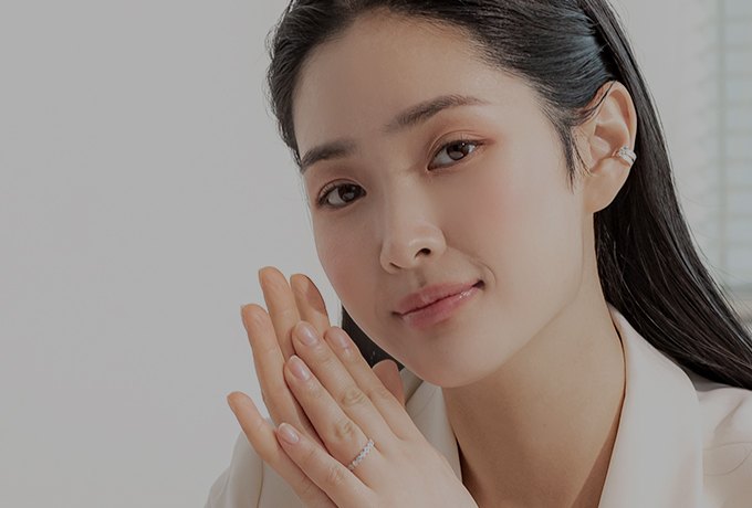 양손을 얼굴 옆에 모은 여성의 탄력 있는 얼굴 라인